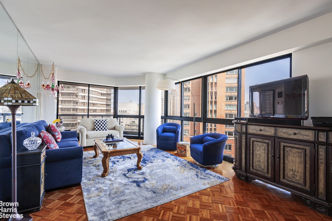 a living room with furniture a flat screen tv and a floor to ceiling window