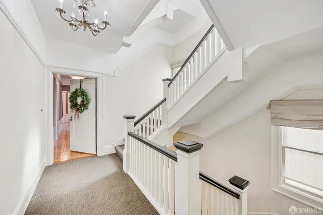 a view of a hallway with wooden floor and a potted plant