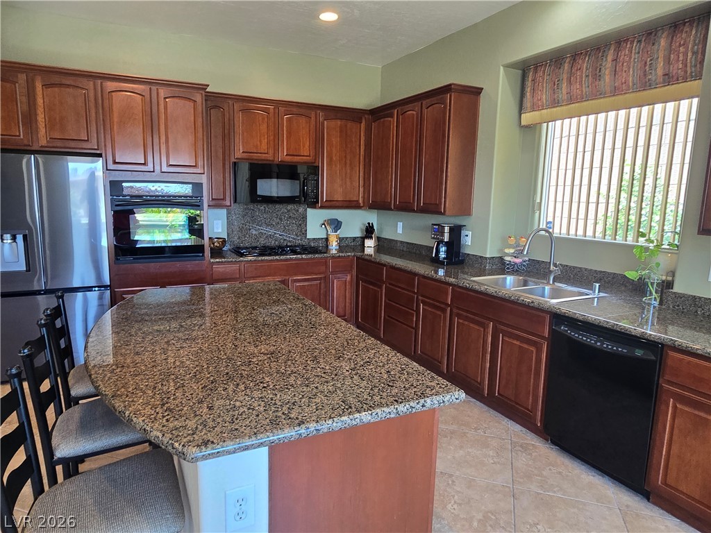 2567 Dirleton Place Henderson, NV 89044 - Photo 14 of 67 A gourmet kitchen boasts rich wood cabinetry, granite countertops, and modern appliances perfect for culinary adventures.