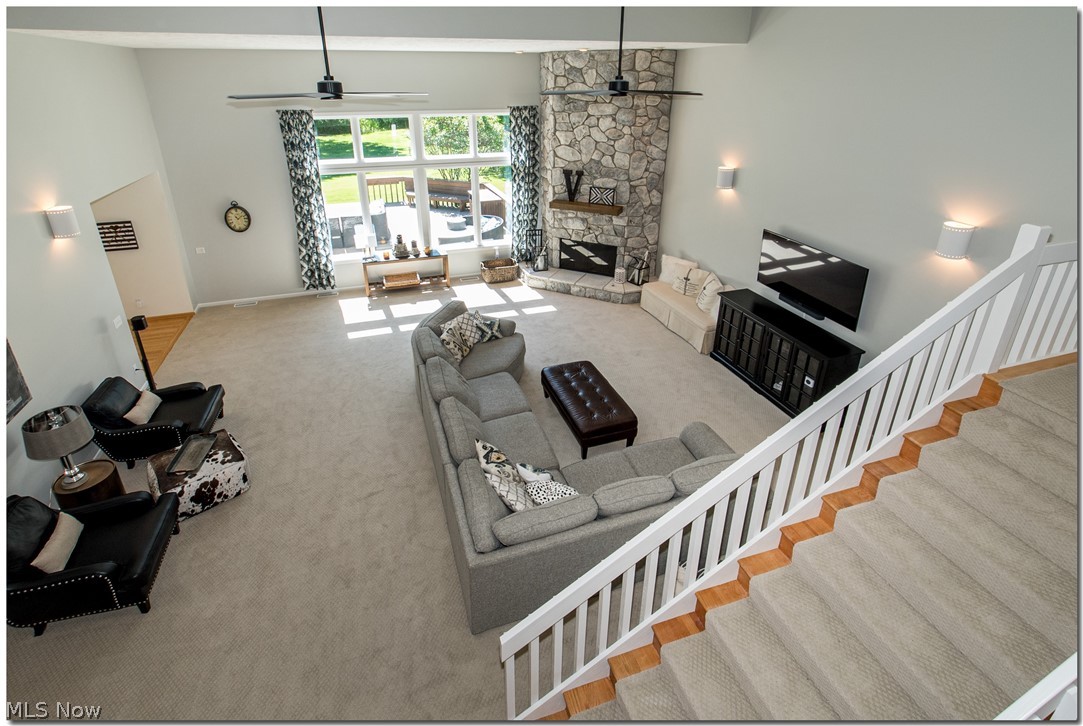 2569 Ginger Wren Road Cleveland, OH 44124 - Photo 5 of 35 STUNNING SUN DRENCHED GREAT ROOM WITH SOARING BEAMED CEILING, PATTERNED NEWER CARPETING, WALL OF WINDOWS , IMPRESSIVE 2 STORY STONE FIREPLACE W/BARN WOOD MANTEL & FARM HOUSE FANS