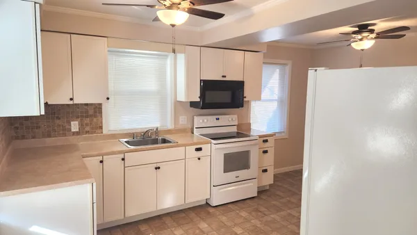 a kitchen with appliances a sink and cabinets