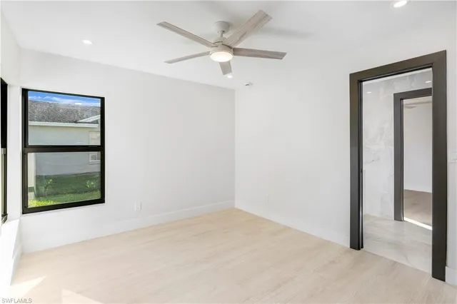 an empty room with a ceiling fan and a window