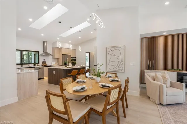 a dining room with stainless steel appliances kitchen island granite countertop a dining table and chairs
