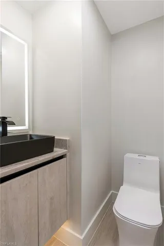 a white toilet sitting next to a bathroom sink