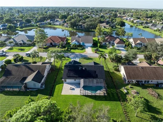 an aerial view of a house with a garden and lake view