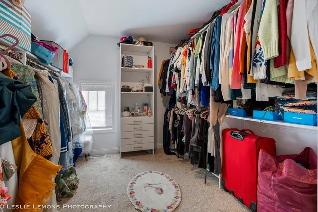 a view of walk in closet with clothes and shoes