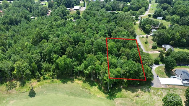 an aerial view of residential house with outdoor space and trees all around