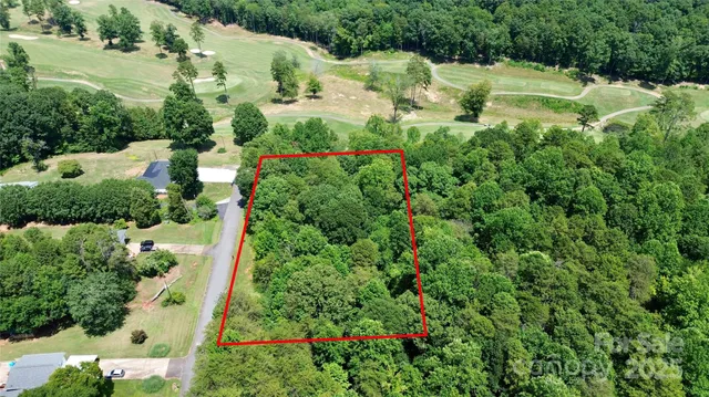 an aerial view of residential house with outdoor space and trees all around
