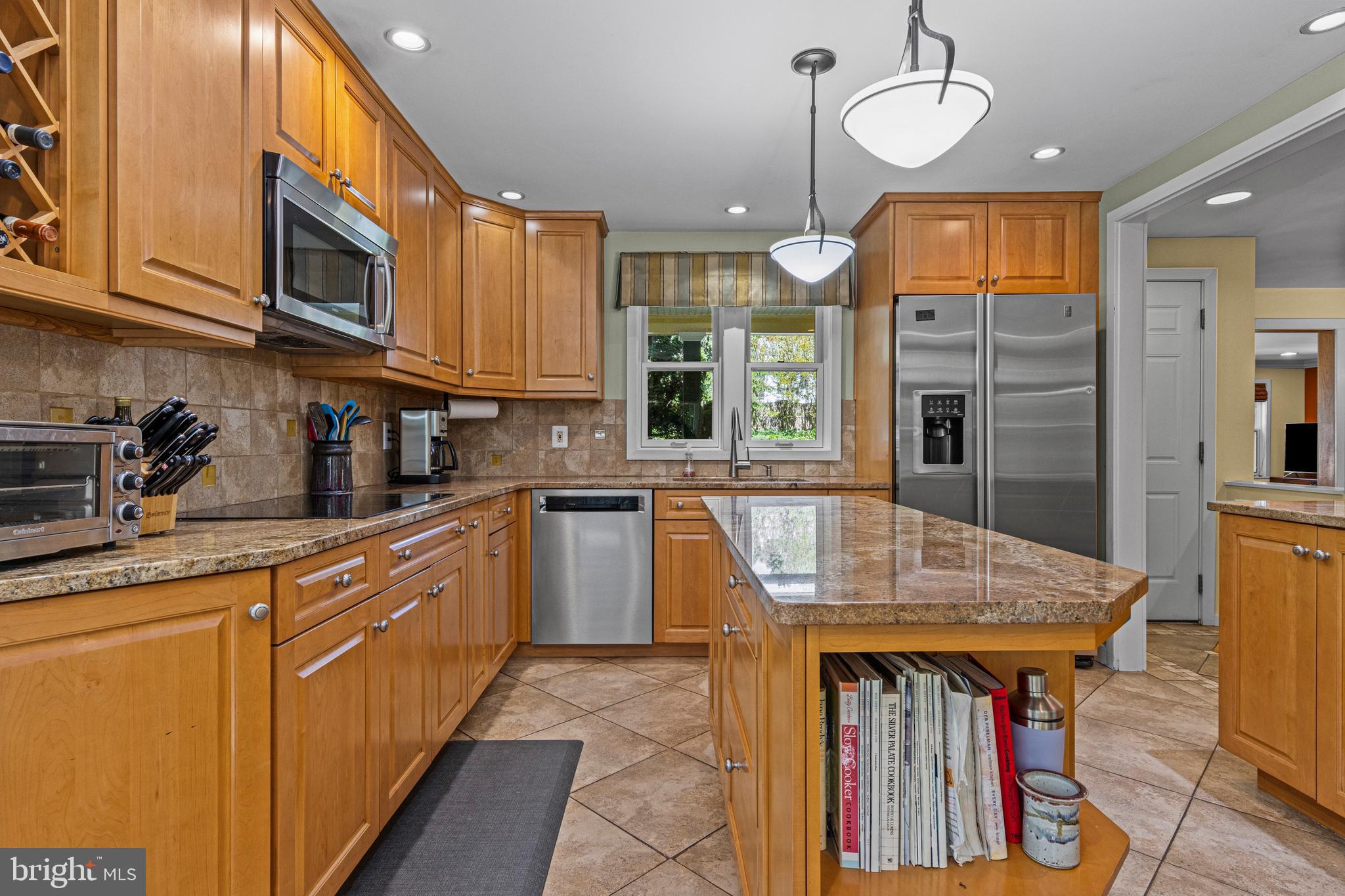231 West Valley Road Wayne, PA 19087 - Photo 32 of 61 a kitchen with stainless steel appliances granite countertop wooden cabinets a dining table and chairs
