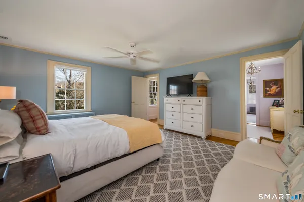 a bedroom with a bed and a lamp on dresser