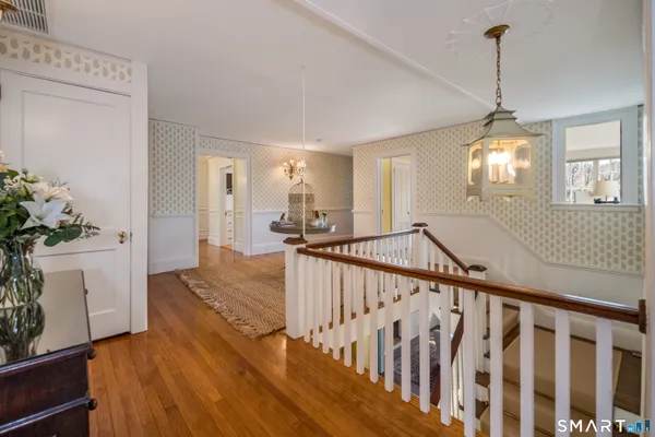 a view of a hallway with wooden floor and staircase