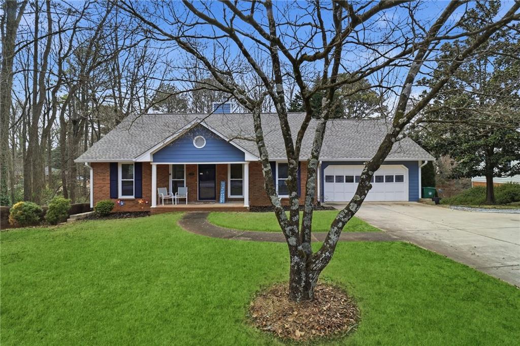 a front view of a house with garden and trees