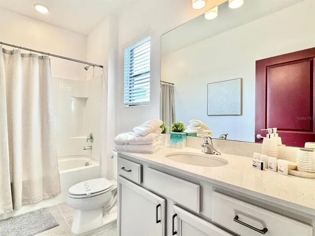 a bathroom with a double vanity sink toilet and shower