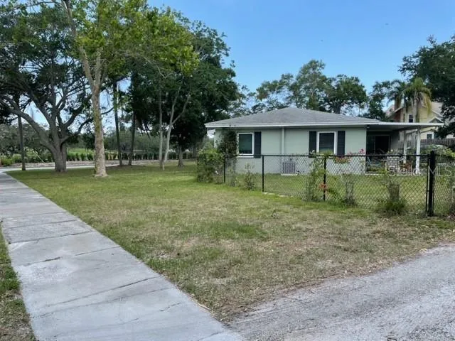 a view of a yard in front of a house with large trees