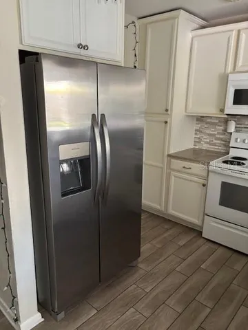 a metallic refrigerator freezer sitting in a kitchen