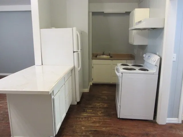 a kitchen with a stove a refrigerator and a more cabinets