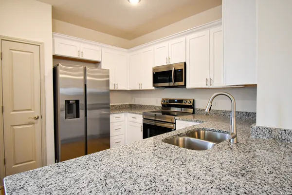 a kitchen with stainless steel appliances granite countertop a stove a sink dishwasher a refrigerator and a microwave