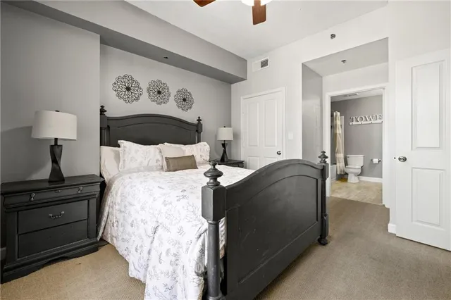 a bedroom with a bed and a lamp on dresser