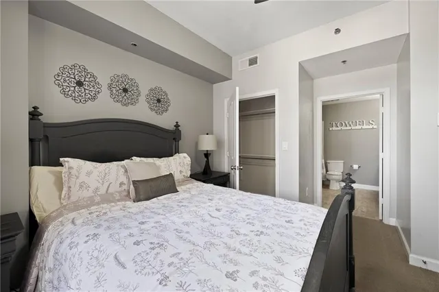 a bedroom with a bed and painting on the wall