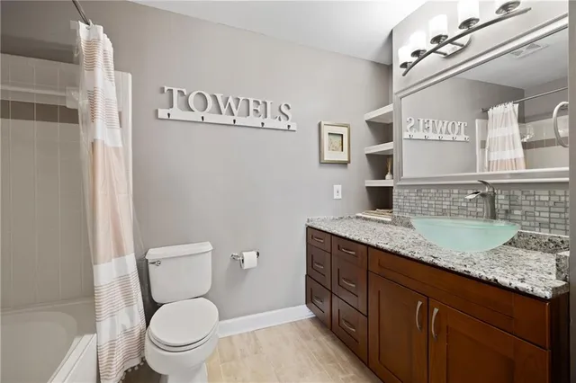 a bathroom with a granite countertop toilet sink and mirror