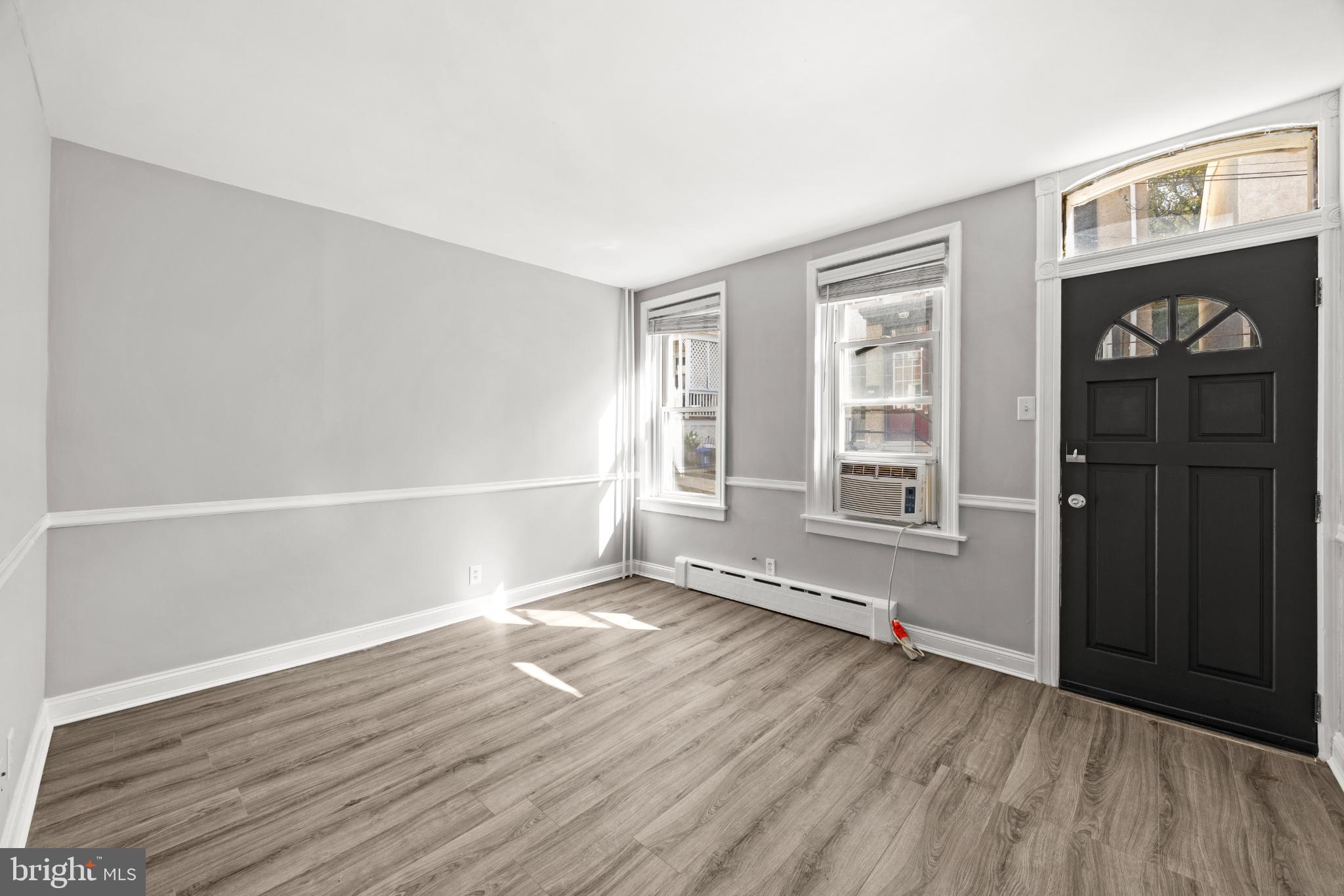 348 Carson Street Philadelphia, PA 19128 - Photo 3 of 27 an empty room with wooden floor and windows