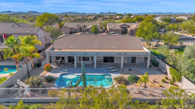 an aerial view of a house with swimming pool and a yard