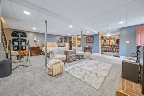 a living room with furniture a large window and gym equipment