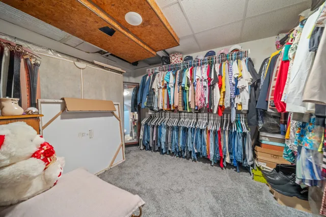 a view of walk in closet with clothes
