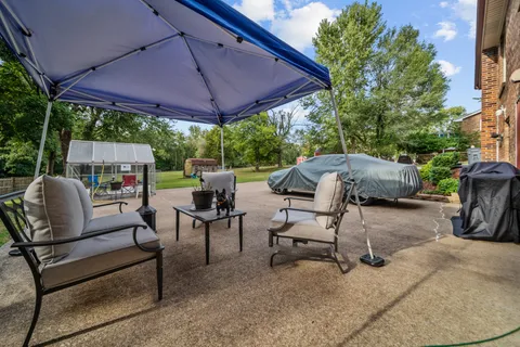 a view of a patio with furniture and a backyard