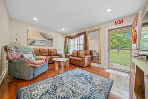 a living room with furniture a rug and a floor to ceiling window