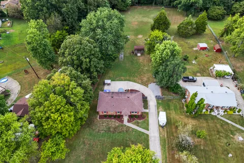 an aerial view of a house with a garden and lake view