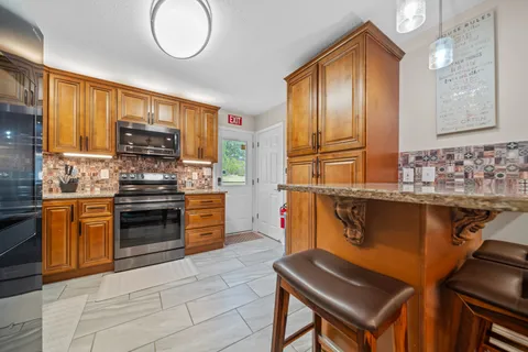 a kitchen with stainless steel appliances granite countertop a stove a sink and a refrigerator