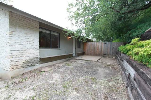 a view of a yard with wooden fence