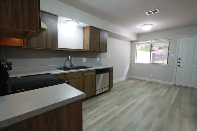 a kitchen with a sink cabinets and a wooden floor
