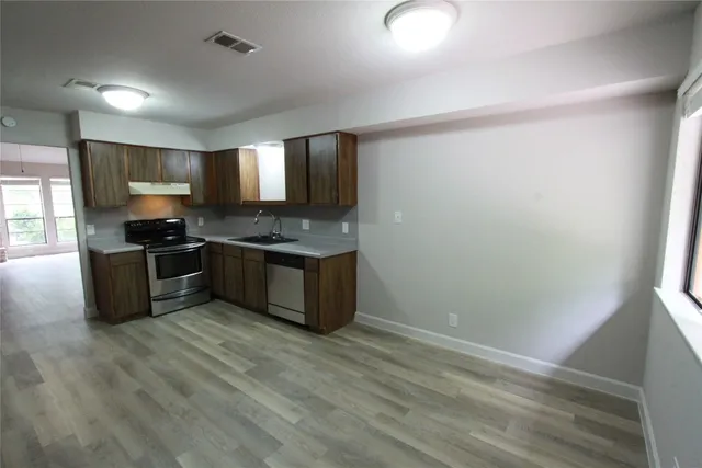 a kitchen with stainless steel appliances granite countertop a stove a sink and a refrigerator