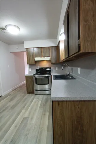 a kitchen with granite countertop a sink and a stove top oven