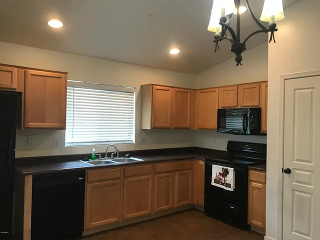 a kitchen with granite countertop a sink cabinets and stainless steel appliances