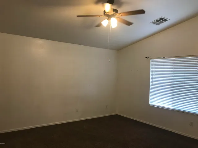 an empty room with a window and a fan