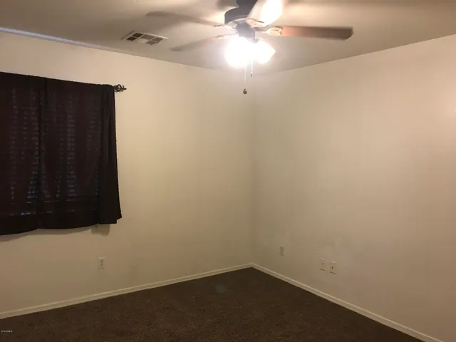 a view of a small space with wooden floor and a ceiling fan