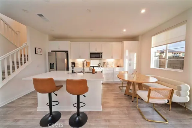 a living room with furniture a dining table and a large window
