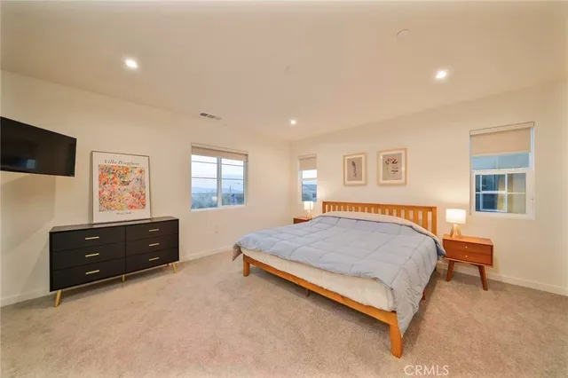 a spacious bedroom with a bed and a dresser