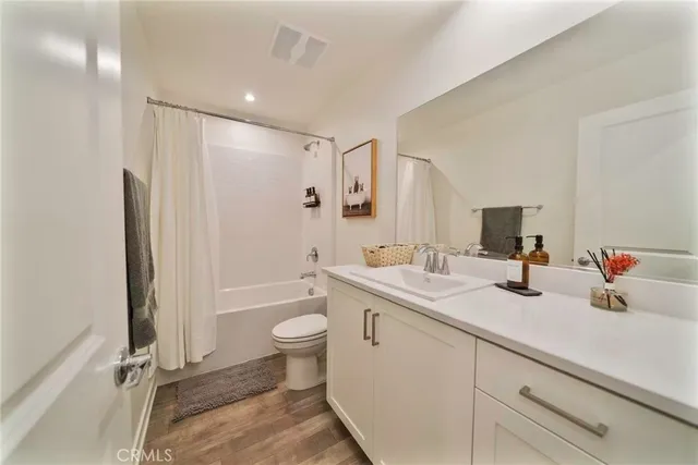 a bathroom with a double vanity sink toilet mirror and shower
