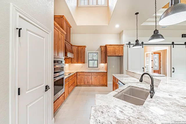 a kitchen with stainless steel appliances granite countertop a refrigerator and a sink