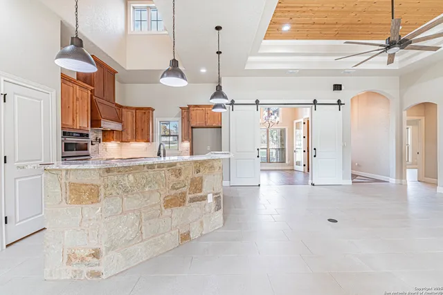 a hallway with white cabinets and chandelier