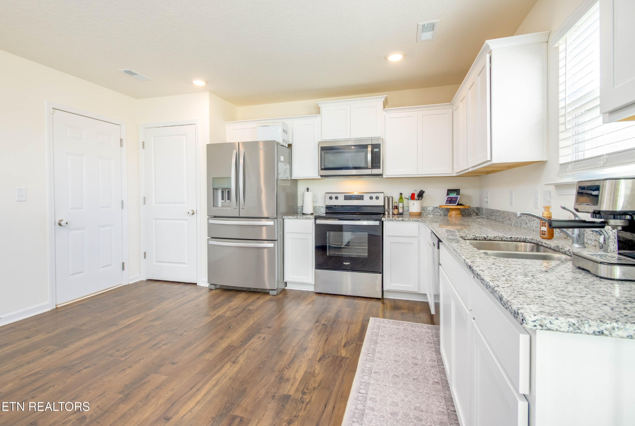 7535 Grasshopper Lane Corryton, TN 37721 - Photo 2 of 28 a kitchen with stainless steel appliances granite countertop a refrigerator a stove top oven a sink and dishwasher with wooden floor