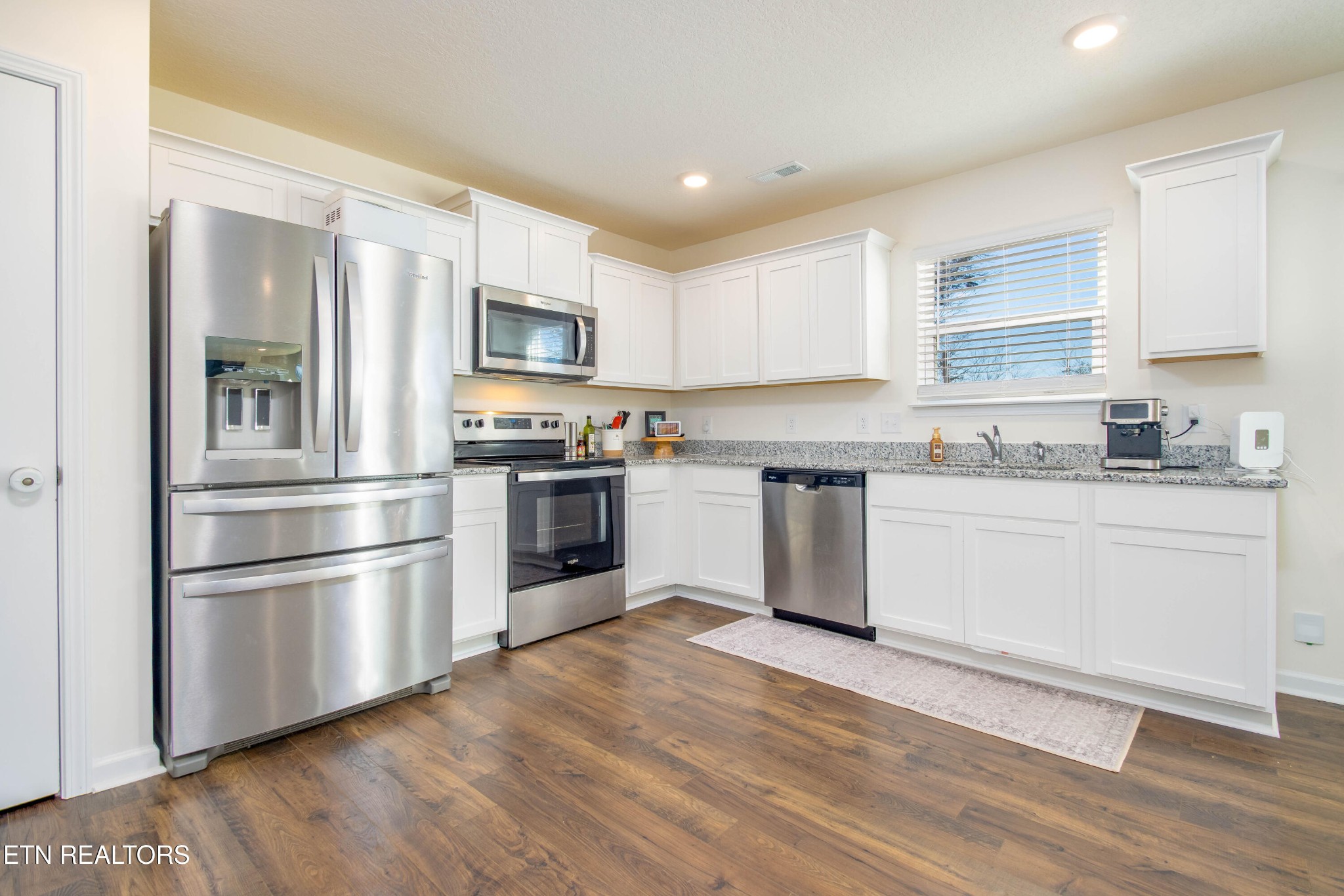 7535 Grasshopper Lane Corryton, TN 37721 - Photo 3 of 28 a kitchen with granite countertop stainless steel appliances and wooden cabinets