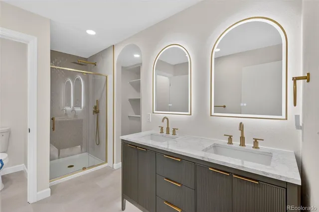 a bathroom with double vanity sinks and a shower