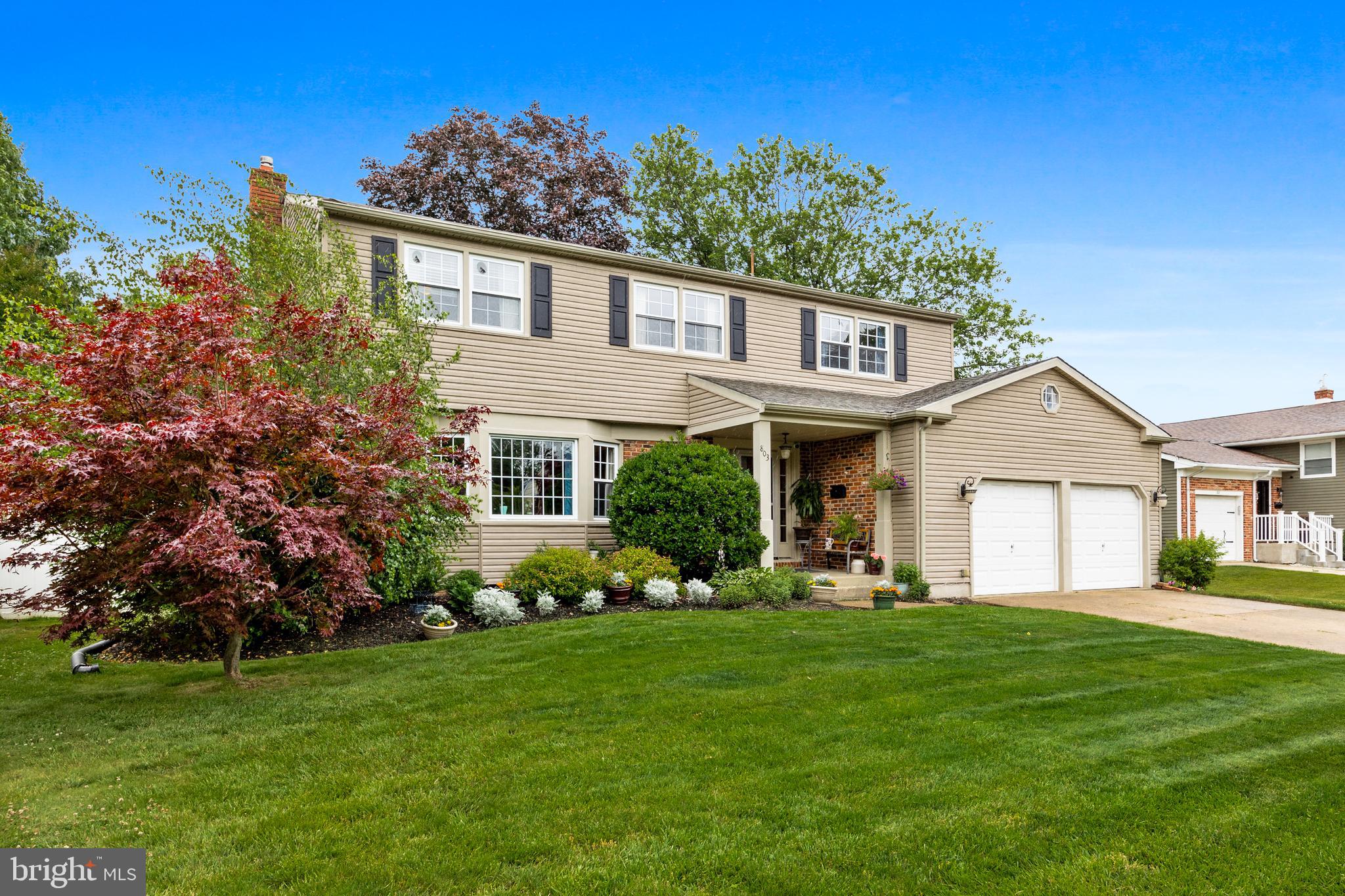 a front view of a house with a yard and trees