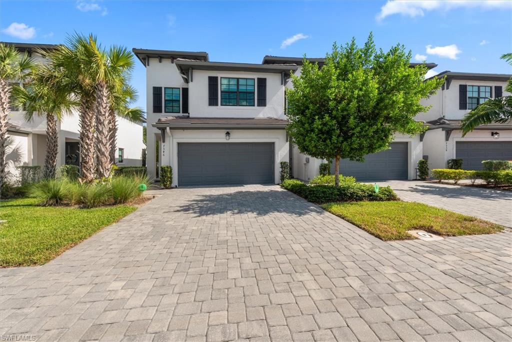 7546 Rockefeller Drive Naples, FL 34119 - Photo 1 of 31 View of front of home featuring decorative driveway, an attached garage, and stucco siding