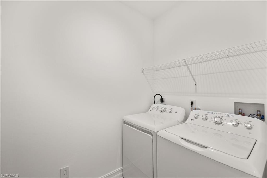 7546 Rockefeller Drive Naples, FL 34119 - Photo 26 of 31 Washroom featuring washer and dryer and baseboards